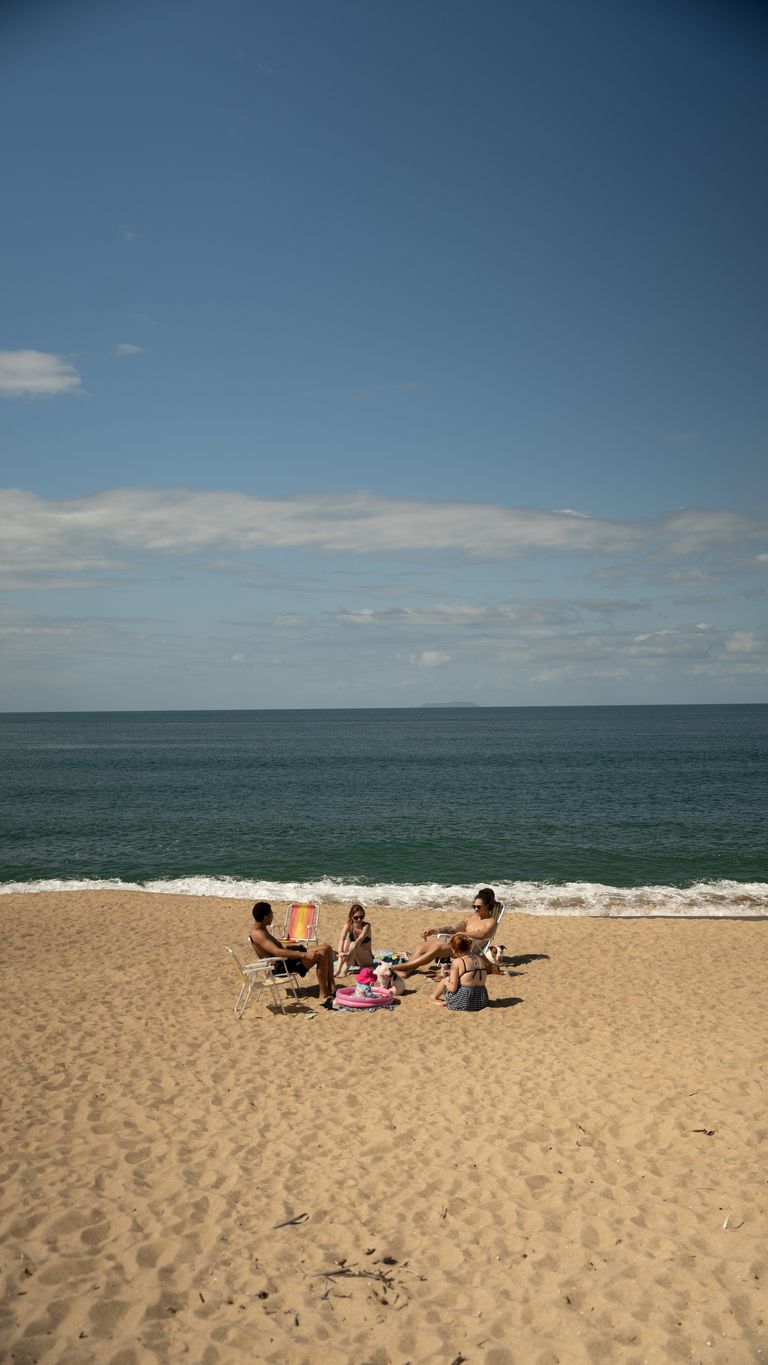 Cadeiras de praia montadas na areia em frente ao mar